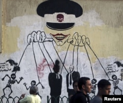 This graffiti near Cairo's Tahrir Square depicts the ruling military council as controlling the presidential elections. (Reuters)