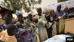 Un grupo de mujeres de Koleram, en el sur de Niger, reciben alimentos para combatir la subnutrición infantil.