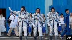 From right, U.S. astronaut Randy Bresnik, Russian cosmonaut Sergey Ryazanskiy and Italian astronaut Paolo Nespoli walk to the Soyuz MS-05 space ship before liftoff from the Baikonur cosmodrome in Kazakhstan, July 28, 2017. 