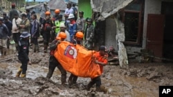 Rescuers carry the body of a person killed in a landslide in Karo, North Sumatra, Indonesia, Nov. 25, 2024. 