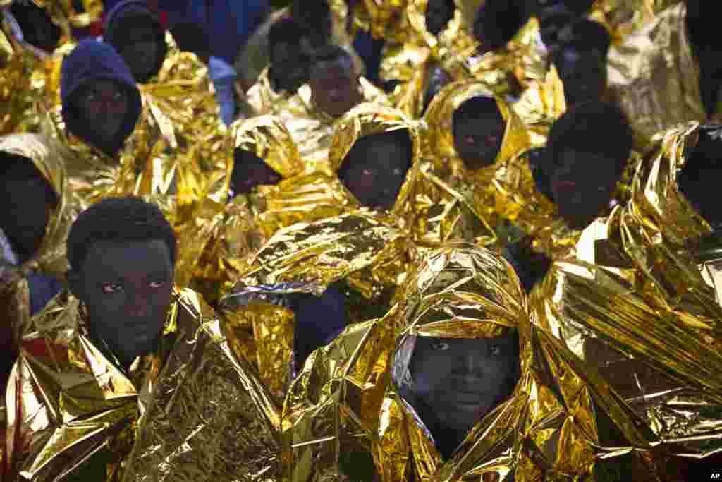 Para migran Afrika menunggu di atas kapal penyelamat Golfo Azzurro, tiba di pelabuhan Messina, Italia.