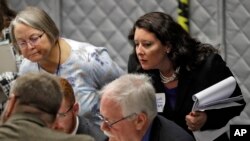 Democratic party observer Rachel May Zysk, right, looks on as volunteers check under- and overvotes during a manual recount for undecided races, Nov. 16, 2018, in Tampa, Fla. 