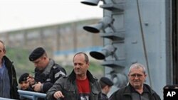 Evacuees from Libya disembark from the Royal Navy frigate HMS Cumberland in Valletta harbor, February 28, 2011