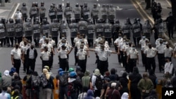 La policía trata de despejar una avenida bloqueada por estudiantes universitarios durante una protesta en la Ciudad de Guatemala el 9 de agosto de 2022. Foto AP.