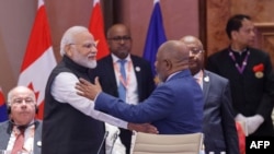 African Union Chairman and Comoros President Azali Assoumani (R) and India's Prime Minister Narendra Modi gesture during the first session of the G20 Leaders' Summit at the Bharat Mandapam in New Delhi on September 9, 2023.