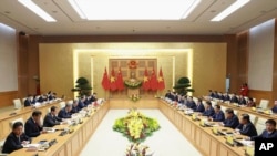 Chinese Premier Li Qiang, fifth left, and Vietnamese Prime Minister Pham Minh Chinh, sixth right, attend a meeting in Hanoi, Oct. 13, 2024. (Duong Van Giang/VNA via AP)