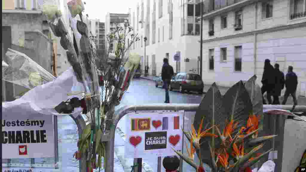 Des fleurs sont attachées à la clôture de sécurité devant le siège de Charlie Hebdo une semaine après l&#39;attaque sur le journal, Paris, France, le 14 janvier 2015.