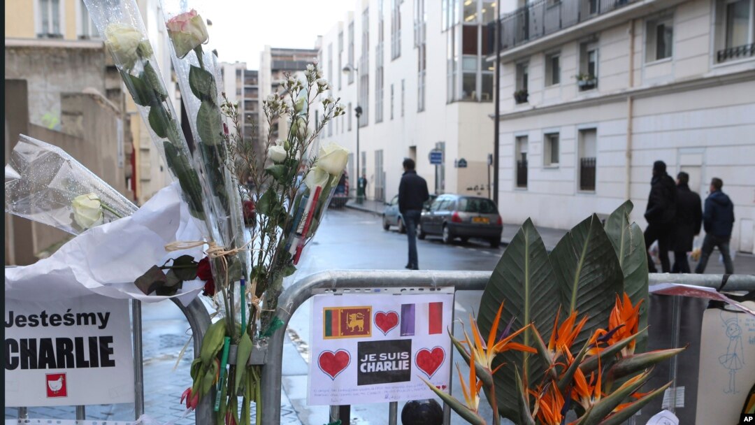 Bunga-bunga dipasang di pagar di luar kantor pusat Charlie Hebdo di Paris, seminggu setelah serangan terhadap tabloid tersebut. (Foto: Dok)
