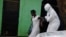 A health worker brings a woman suspected of having contracted the Ebola virus to an ambulance in Monrovia, Liberia, Sept. 15, 2014.