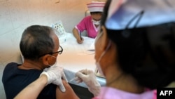 一位男士在金邊一家醫院被接種阿斯利康新冠疫苗。 (2021年3月10日)