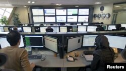 Iranian technicians monitor data flow in the control room of an internet service provider in Tehran, February 15, 2011