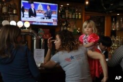 Christine Fox and her daughter Emmylou Fox from Washington state wait for the results of the U.S. midterm elections during a gathering organized by Democrats Abroad in Beijing, China, Nov. 7, 2018.