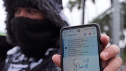 ARCHIVO - Un migrante que busca asilo sostiene la aplicación CBP One que muestra que su cita fue cancelada después de que el presidente Donald Trump asumió el cargo, el lunes 20 de enero de 2025, en Matamoros, México.
