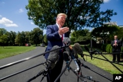 President Donald Trump speaks with reporters on the South Lawn of the White House, Aug. 21, 2019, in Washington.