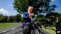 President Donald Trump speaks with reporters before departing on Marine One on the South Lawn of the White House, Aug. 21, 2019, in Washington. 