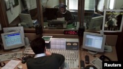 FILE - A Vatican Radio reporter speaks during a live program, April 10, 2001.