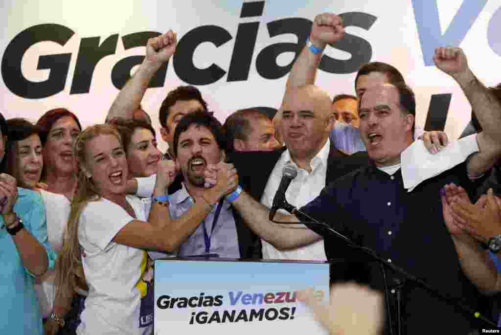 Lilian Tintori (centef L), wife of jailed Venezuelan opposition leader Leopoldo Lopez, celebrates next to candidates of the Venezuelan coalition of opposition parties (MUD) during a news conference on the election in Caracas. Opposition won control of the legislature from the ruling Socialists for the first time in 16 years, giving them a long-sought platform to challenge President Nicolas Maduro.
