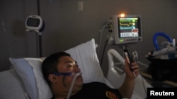 Duc Nguyen speaks with his wife using FaceTime on New Year's Day from inside the coronavirus disease (COVID-19) unit at United Memorial Medical Center in Houston, Texas, U.S., Jan. 1, 2021. 