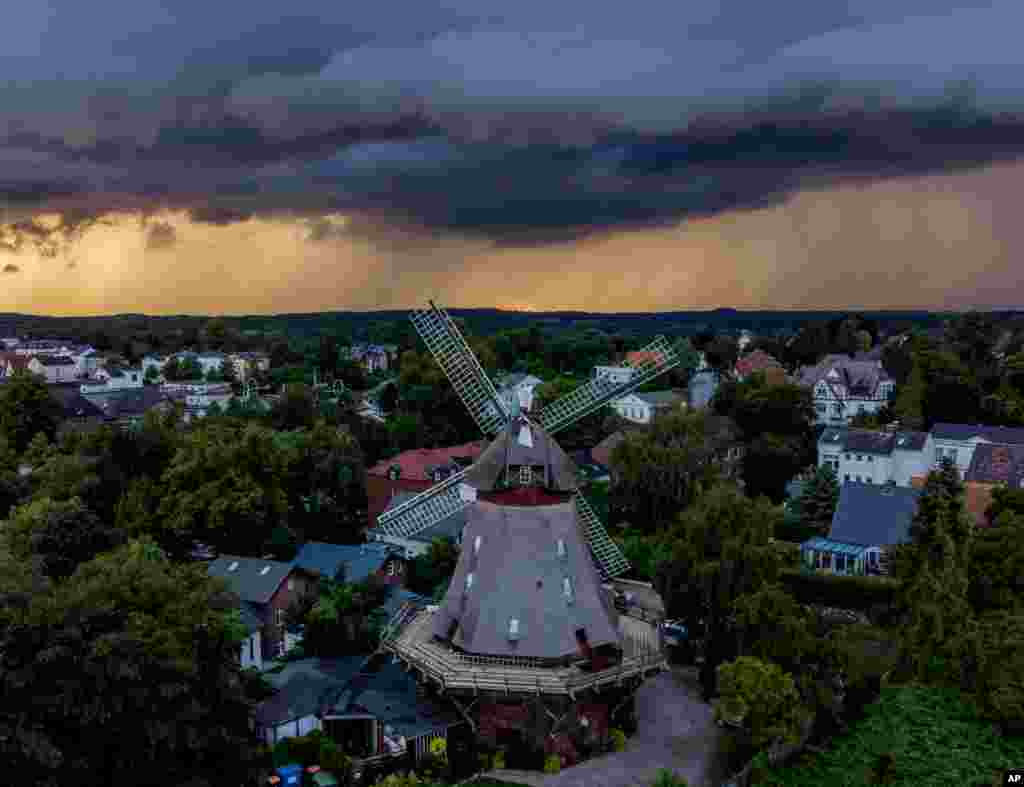 Clouds drift over a windmill in Eutin, northern Germany, during a thunderstorm nearby, July 28, 2021.