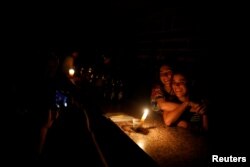 People pose for a picture at a bar during a blackout in Caracas, Venezuela, March 29, 2019.