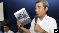 Youk Chhang, a leading Cambodian genocide researcher, shows a copy of the Cambodian version of a Khmer Rouge history textbook to teachers in Takeo province, July 3, 2012.