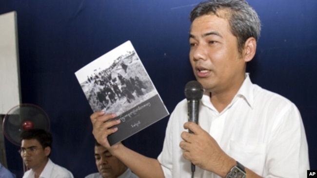 Youk Chhang, a leading Cambodian genocide researcher, shows a copy of the Cambodian version of a Khmer Rouge history textbook to teachers in Takeo province, July 3, 2012.