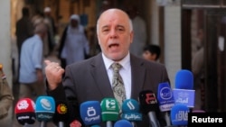 FILE - Iraqi Prime Minister Haider al-Abadi speaks to reporters in the Shi'ite holy city of Najaf, south of Baghdad, Oct. 20, 2014. 