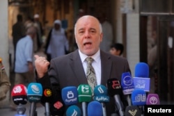FILE - Iraqi Prime Minister Haider al-Abadi speaks to reporters in the Shi'ite holy city of Najaf, south of Baghdad, Oct. 20, 2014.