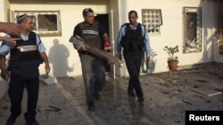 Một chuyên viên về chất nổ của cảnh sát Israel cầm mảnh vỡ của tên lửa bắn từ Dải Gaza vào thị trấn Ofakim, miền nam Israel, 18/11/12