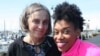 Angela Tucker and her adoptive mom, Teresa Burt, pause during a walk on the Bellingham waterfront. (Claire Morin-Gibourg/VOA)