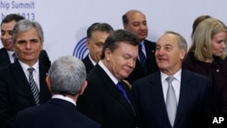 Ukrainian President Viktor Yanukovych, center, arrives on the podium for a group photo at an Eastern Partnership Summit in Vilnius on Friday, Nov. 29, 2013. 