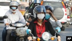 Cambodians wear masks to avoid the contact of coronavirus in Phnom Penh, Cambodia, Tuesday, Jan. 28, 2020. (AP Photo/Heng Sinith)