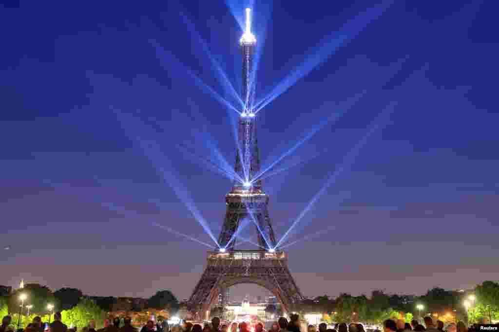 The Eiffel Tower is illuminated during a light show to celebrate its 130th anniversary in Paris, France, May, 15, 2019.