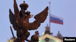 A sculpture of a double-headed eagle, a national symbol of Russia, is seen in front of a Russian national flag flying at half-mast on the roof of the State Hermitage Museum in St. Petersburg, Nov. 1, 2015.