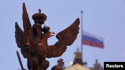俄罗斯国家的象征—双头鹰雕塑。背后是俄罗斯国旗。
