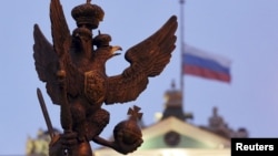 A sculpture of a double-headed eagle, a national symbol of Russia, is seen in front of a Russian national flag flying at half-mast on the roof of the State Hermitage Museum in St. Petersburg, Nov. 1, 2015.