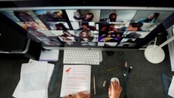 FILE PHOTO: A student takes classes online with his companions using the Zoom app at home