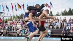 Tia Rope dan Joonas Saukkonen (kiri) dan Katja Hyvarinen dan Jukka Podduikin, semua dari Finlandia, berkompetisi dalam Kejuaraan Dunia Menggendong Istri, di Sonkajarvi, Finlandia, 2 Juli 2016. 