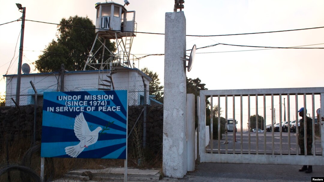 Seorang penjaga perdamaian PBB menjaga pintu masuk markas PBB dekat perbatasan Quneitra antara Dataran Tinggi Golan yang dikuasai Israel dengan Suriah (29/8). (Reuters/Ronen Zvulun) 