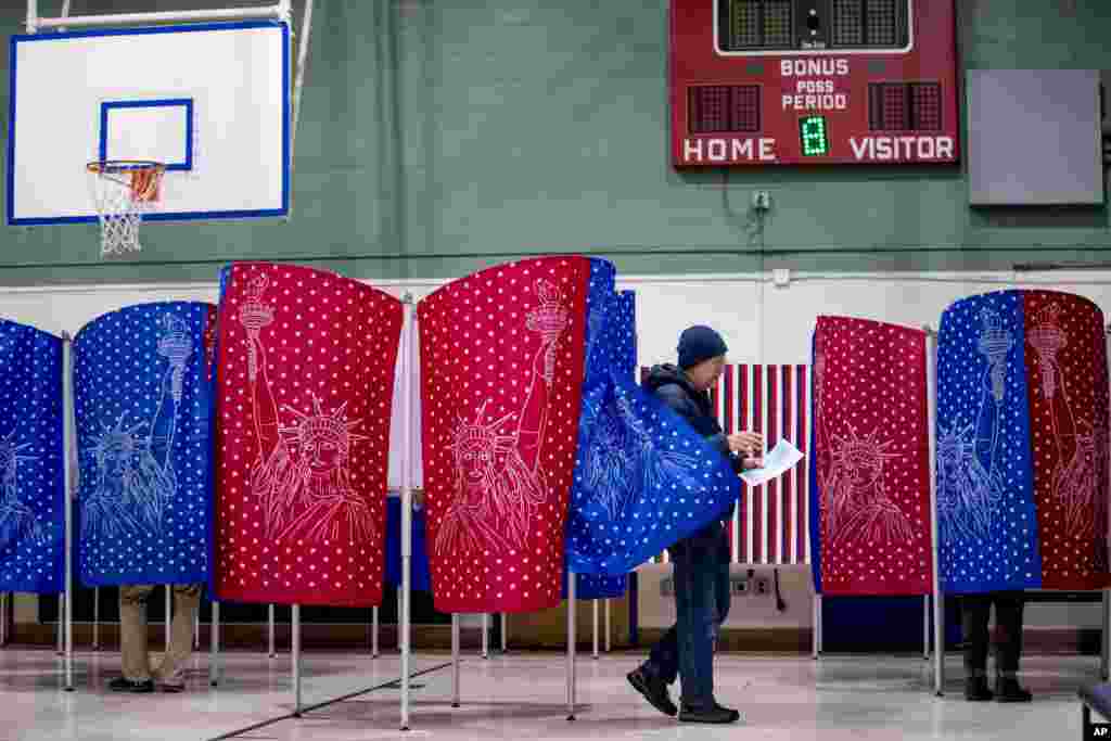 A man walks out of a voting booth during the New Hampshire Primary in Manchester, N.H., Feb. 11, 2020.