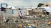 A woman walks through the UNMISS camp in Malakal, where rain has turned the dirt paths into mud.