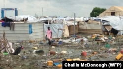 A woman walks through the UNMISS camp in Malakal, where rain has turned the dirt paths into mud.