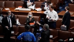 Members of Congress prepare to evacuate the floor as protesters try to break into the House Chamber at the U.S. Capitol, in Washington, Jan. 6, 2021. 