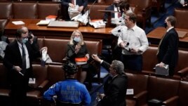 Members of Congress prepare to evacuate the floor as protesters try to break into the House Chamber at the U.S. Capitol, in Washington, Jan. 6, 2021.