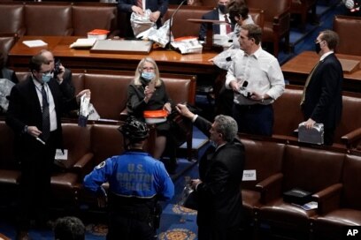 Members of Congress prepare to evacuate the floor as protesters try to break into the House Chamber at the U.S. Capitol, in Washington, Jan. 6, 2021.