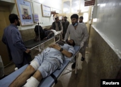 Injured men are brought in for treatment at a hospital after a suicide attack in Asadabad, capital of Kunar province, Afghanistan, Feb. 27, 2016.