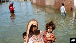 A woman escapes to higher ground from her flooded village in the Mirpur Khas district of Pakistan's Sindh province.