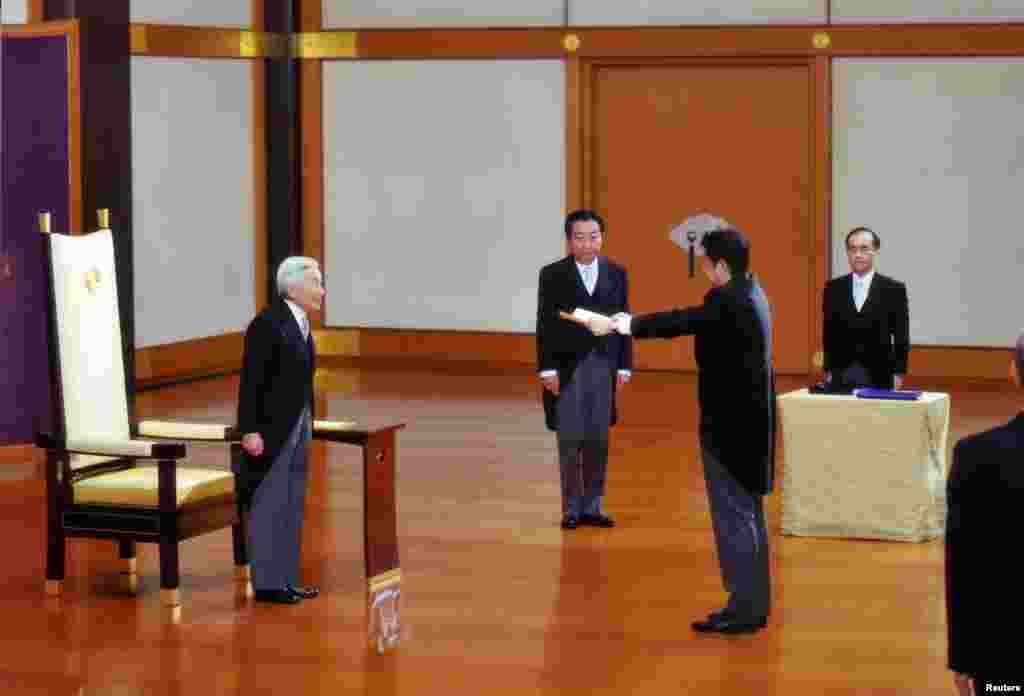 26일 도코 왕궁에서 아키히토 일본 국왕(왼쪽)으로부터 임명장을 받는 아베 신조 신임 총리(오른쪽 두번째).