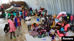 Families displaced by recent fighting in South Sudan, camp in a warehouse inside the United Nations Mission in Sudan facility in Jabel, on the outskirts of capital Juba, Dec. 23, 2013.