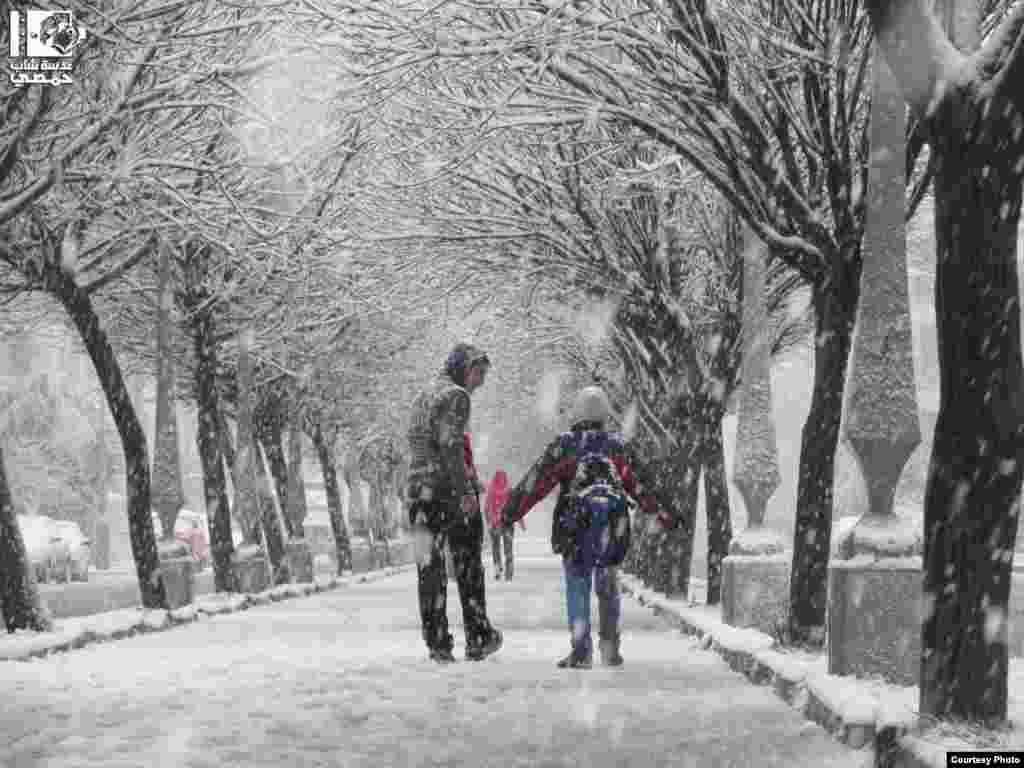 2013年1月9日，敘利亞人在雪中走過霍姆斯的古塔區。(Lens Young Homsi)